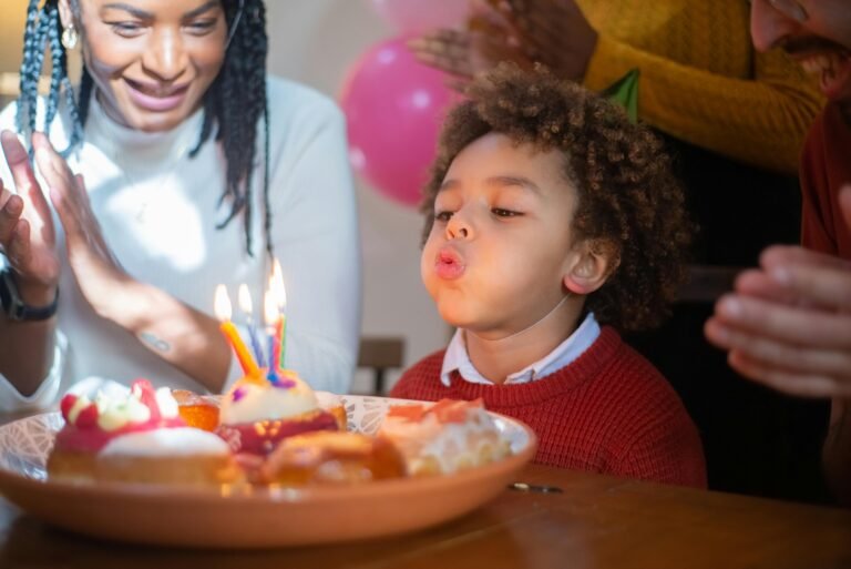 A joyful birthday celebration with a child blowing out candles surrounded by family, capturing a happy moment.